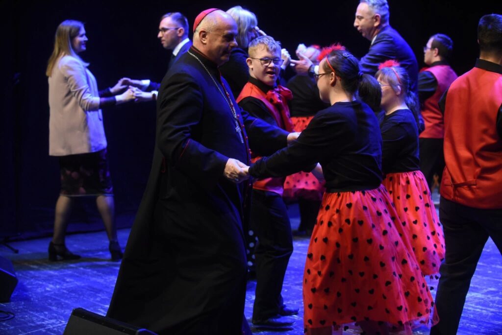 Uczestnicy w czasie wspólnego tańca na scenie podczas obchodów Dnia Godności Osób z Niepełnosprawnością Intelektualną