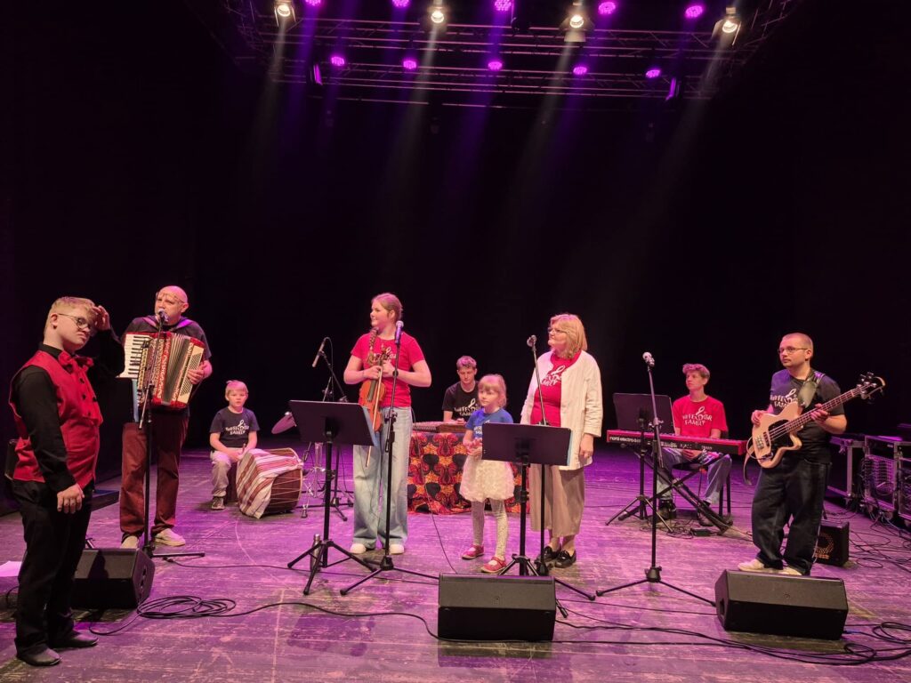 Zespół muzyczny i uczestnicy wydarzenia na scenie podczas występu w Centrum Kultury w Lublinie