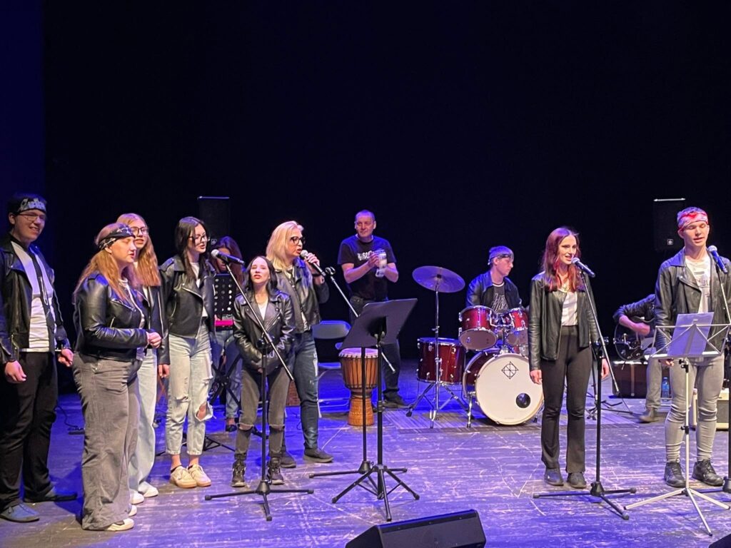Zespół muzyczny i uczestnicy wydarzenia na scenie podczas występu w Centrum Kultury w Lublinie
