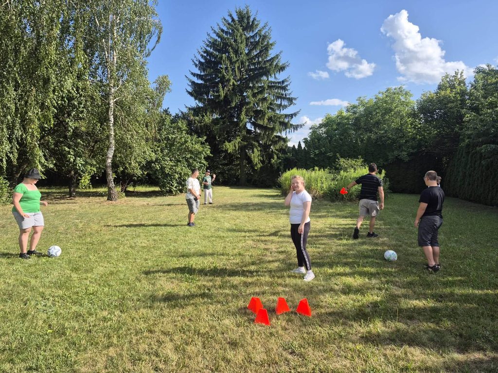 Uczestnicy świetlicy biorą udział w aktywności sportowej na świeżym powietrzu na terenie ośrodka.