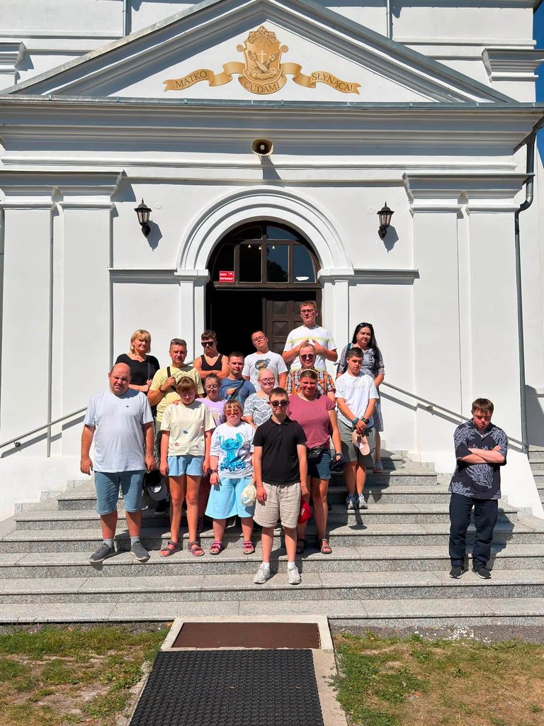 Pamiątkowe zdjęcie uczestników wycieczki na schodach przed kościołem w Hrubieszowie.