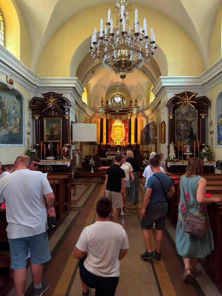 Uczestnicy wycieczki zwiedzają wnętrze zabytkowego kościoła w Hrubieszowie.